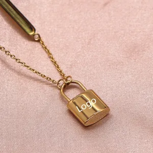 Gold lock pendant necklace detail shot, elegant clavicle chain with side bar ornament chic.