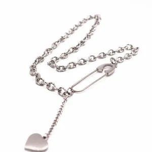 Detailed close-up of the stylish titanium steel safety pin and heart pendant necklace.
