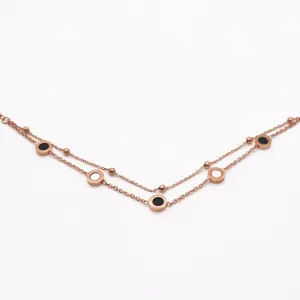 Stainless steel double layer bracelet with black and white disc charms and delicate beads.