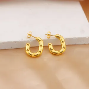 Close-up detail of gold-plated stainless steel horseshoe stud earrings with cute star engravings.