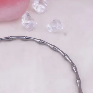 Close-up detail of silver stainless steel bamboo node choker necklace, stylish metallic jewelry.