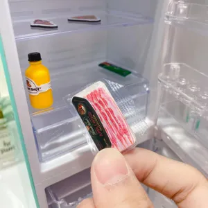Detailed close-up shot of miniature toy refrigerator set with cute food items.