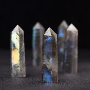 Detail view of polished crystal tower wand showing natural iridescent flashes on dark background.