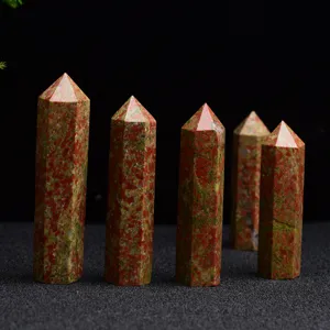 Détail de la baguette en cristal unakite montrant la structure hexagonale polie et le jaspe rouge vert.