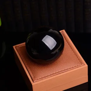Vue detaillee d'une sphere en cristal d'obsidienne noire polit pour la maison avec coffret.