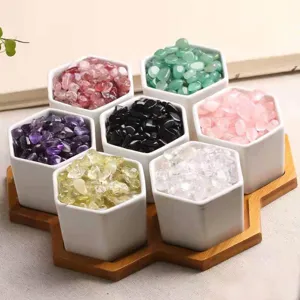 Detailed view of colorful crystal chips in hexagonal ceramic pots on a wooden tray display.