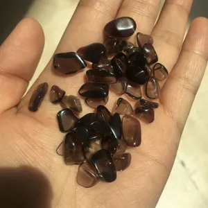 Close-up detail of natural tumbled smoky quartz crystal chips, smoothly polished stones.