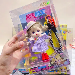 Detailed view of the cute doll pendant in transparent box, featuring delicate plaid dress and hat.
