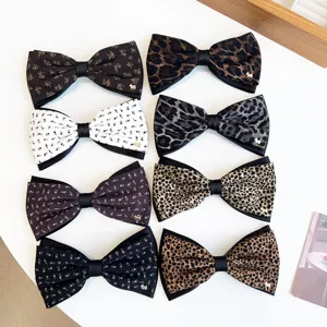 Detailed view of vintage bow hair clips featuring floral prints and chic leopard patterns.