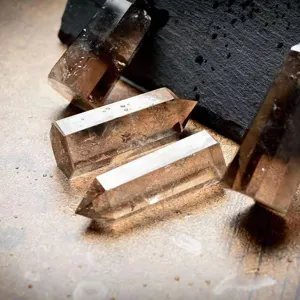 Vue détaillée de colonnes de quartz fumé naturel poli avec une pointe unique.