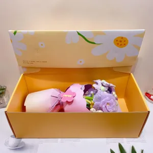 Detail view of handmade fabric flower bouquet in yellow gift box with cute daisy pattern design.