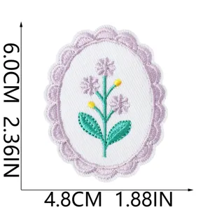 Detail of embroidered floral patch showing intricate purple flowers and scalloped border design.