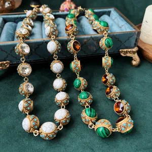 Primo piano sui dettagli della catena maglione in pietra preziosa di malachite dorata.
