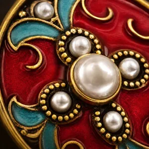 Gedetailleerde close-up van vintage cloisonne emaille oorbellen met parels en rode blauwe rol.