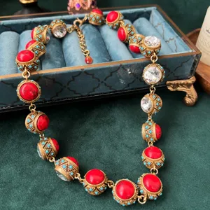 Collana in stile barocco vintage con pietre rosse, cristalli trasparenti e dettagli turchesi.