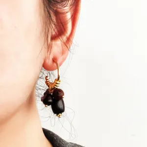 Close-up detail van vintage houten kralen oorringen gedragen aan oor, retro stijl.