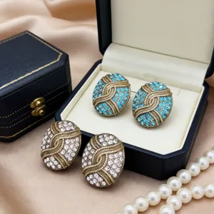 Gedetailleerd zicht op vintage ovale strass oorbellen met ingewikkeld antiek messing.