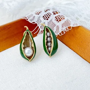 Vintage asymmetrische groene geëmailleerde erwtenpeul parel oorbellen, elegante Franse stijl.