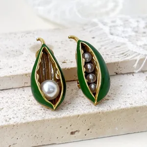 Prachtige asymmetrische groene emaille erwt peul parel oorbellen, gouden detail.
