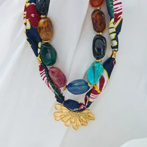 Collar de bufanda de tela con cuentas de resina colorida y colgante de flor dorada.