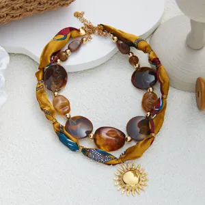 Collar multicapa de cinta de tela con cuentas acrílicas marrones y colgante de sol dorado