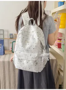 Detailed view of a cute star printed casual school backpack with plush star pendant, lifestyle scene.