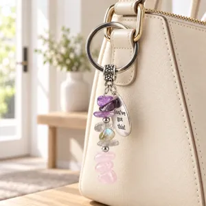 Vue détaillée d'un porte-clés en cristaux avec améthyste et quartz rose suspendu au sac.