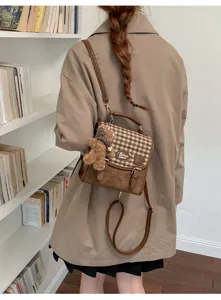 Mini sac à dos vintage à carreaux pour femme, élégant sac bandoulière marron avec pendentif.