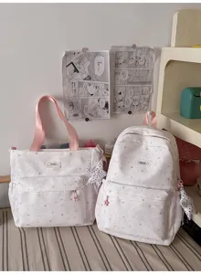 Detail shot of cute star print school backpack and tote bag set in soft pink style.