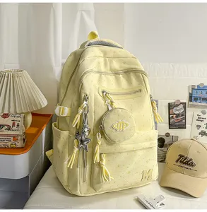 Stiloso zaino scolastico giallo con motivo a stelle e tasche multiple per gli studenti.