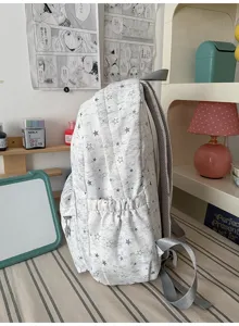 Detail shot of grey star print canvas backpack side view, showing side pocket and durable straps.