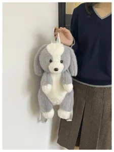 Gros plan détaillé d'un adorable sac à dos en peluche chien gris et blanc au tissu doux.