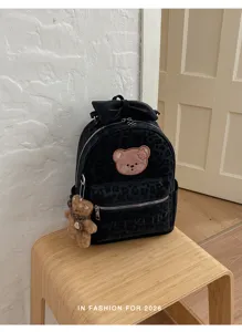 Black velvet leopard print backpack detail view with cute bear patch and bow decoration.