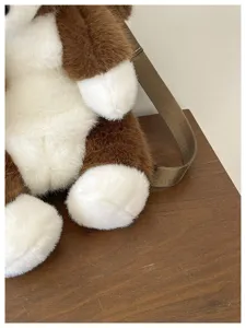 Gros plan de détail de la surface mignonne du sac à dos pour chien en peluche bicolore marron.