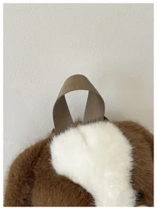Détail sac à dos chien peluche, gros plan texture tissu moelleux marron et blanc mignon.