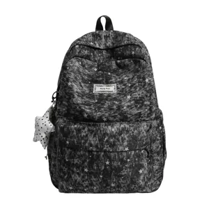 Detailed view of the dark denim style backpack featuring a cute white star print and charm.