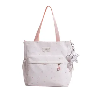 Cute pink star print canvas tote bag with front pocket and shoulder handles for daily use.