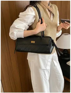Detailed shot of black quilted PU leather shoulder bag with chic turn lock and side ribbons.