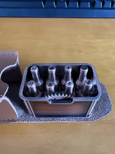 Gedetailleerd overzicht van creatieve mini bierfles metalen dobbelset met handige lederen etui.