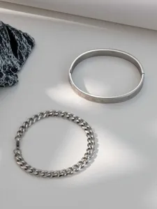 Stainless steel Roman numeral bangle and Cuban chain bracelet set, high-end jewelry detail.