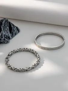 Detail shot of stainless steel Byzantine chain and Roman numeral bangle jewelry set.