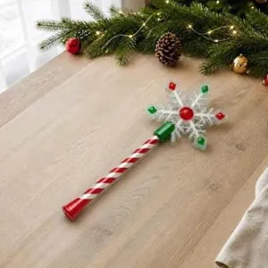 Close-up detail of Christmas snowflake wand with festive candy cane handle on wooden table.