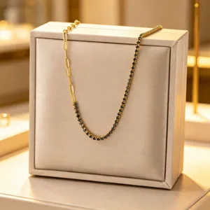 Squisita collana in acciaio al titanio dorato con catena paperclip e zirconi neri.