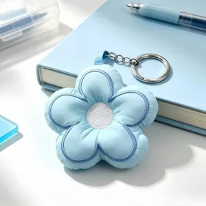 Blue plush flower keychain detail, cute padded five-petal floral bag charm accessory.