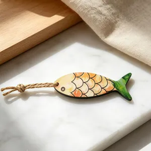Nahaufnahme eines kreativen bunten Holzfisch-Anhaengers Schluesselanhaenger mit Hanfseil.
