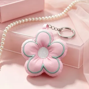 Cute embroidered puffy flower keychain detail, pink fabric five-petal bag charm pendant close up