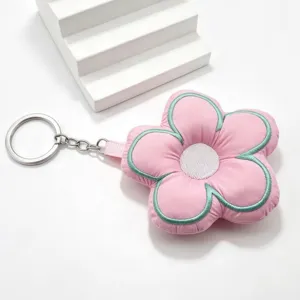 Cute pink five-petal flower plush keychain with green embroidery, soft fabric bag pendant.