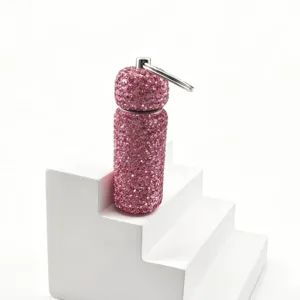 Pink rhinestone refillable bottle keychain detail view, sparkling diamond charm for bag.