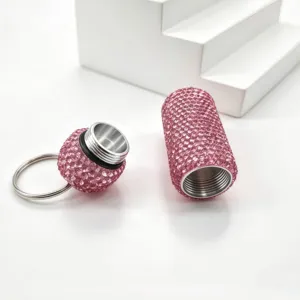 Close-up detail of a sparkling pink rhinestone capsule keychain pill bottle pendant.