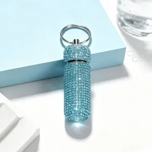 Close-up detail of the sparkling blue rhinestone keychain bottle pendant, showing crystal craft.